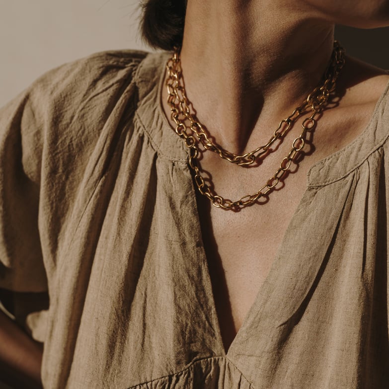 Woman in Brown Dress and Gold Necklace